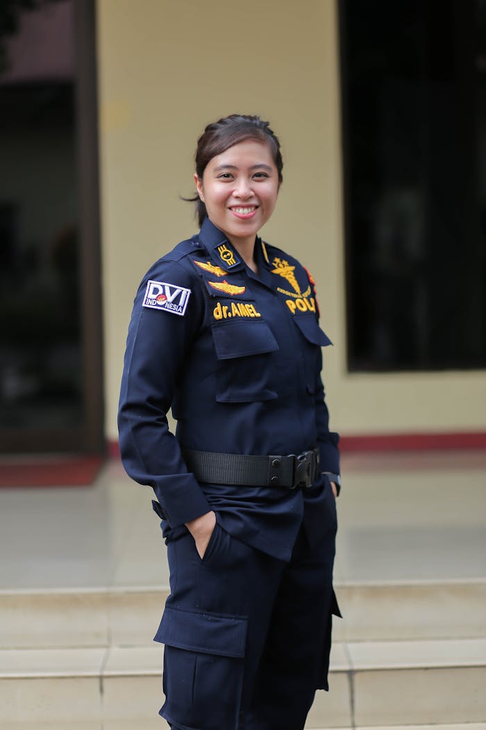 Asian female police officer smiling confidently while standing outdoors in Jakarta.